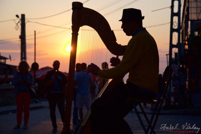 Street photo with a harp singer towards the end of another night.