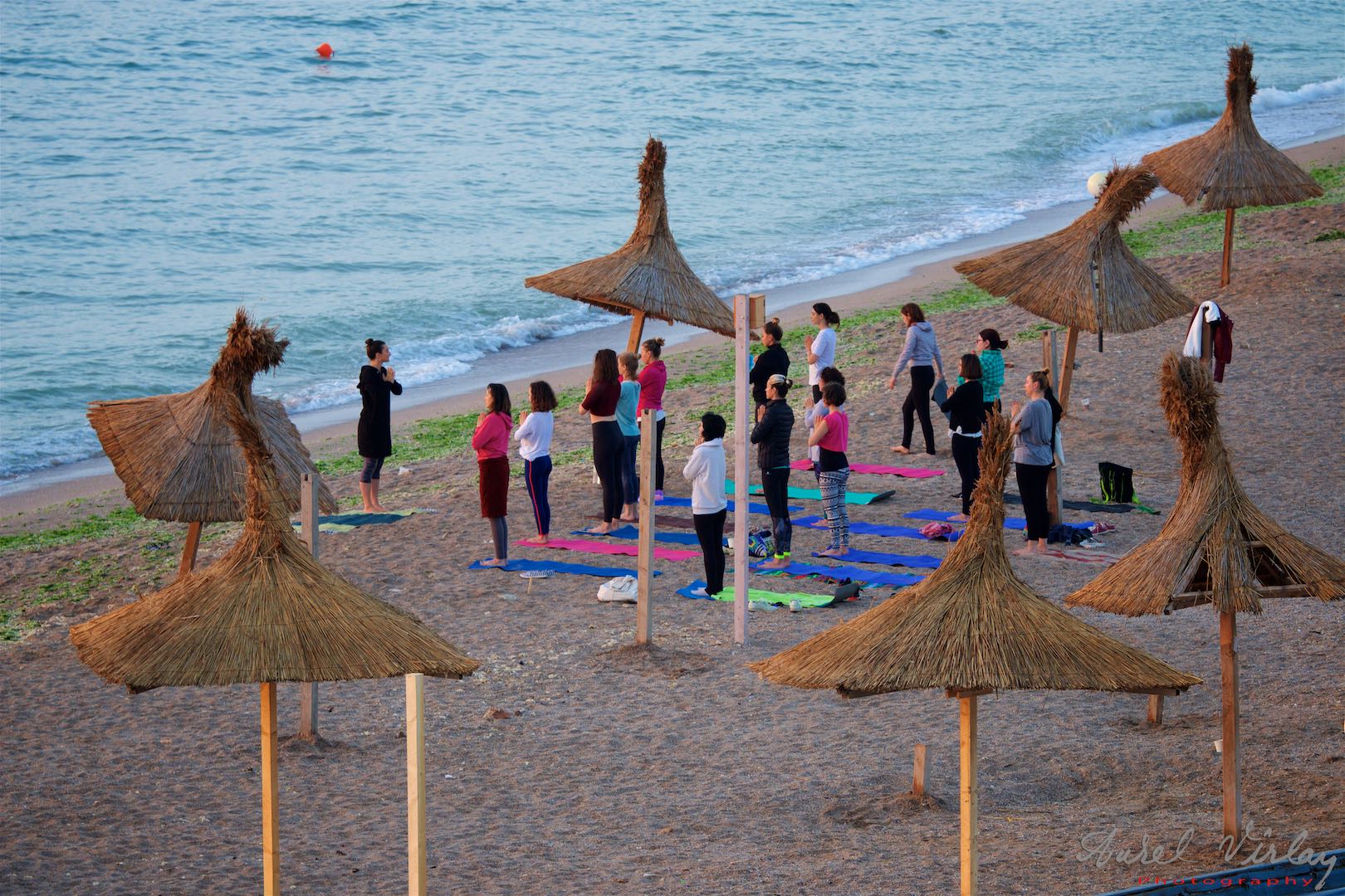 A first-hour Yoga class on an empty beach.