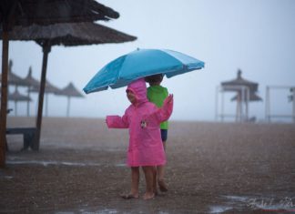 Who's happier? Is this pink girl in the summer rain or her photographer?