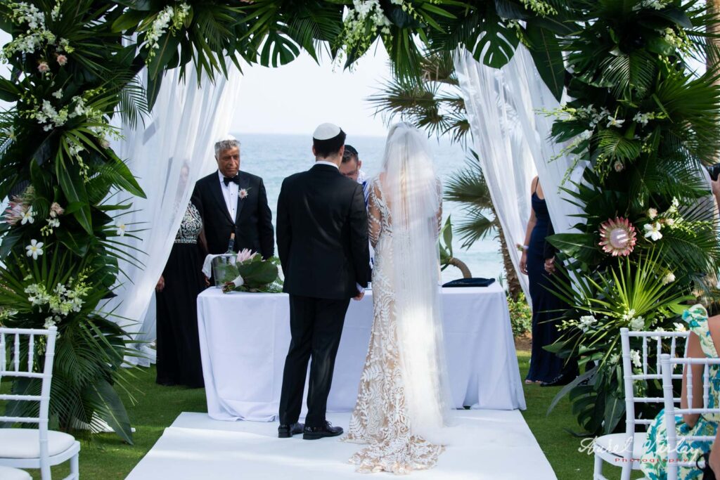 The altar of the wedding ceremony is in the garden of the Kempinski Hotel, on the shores of the Mediterranean Sea.